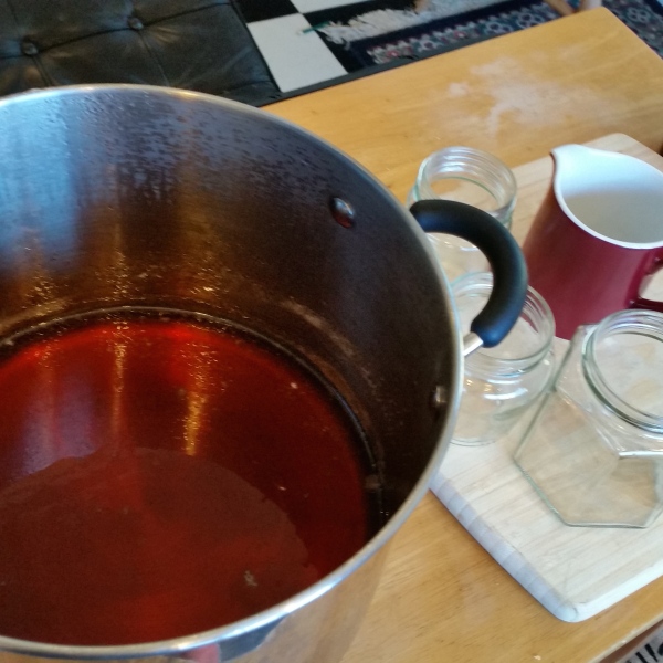 I carefully place the hot jam onto a wooden board , with jars and a jug that has been pre-warmed.
